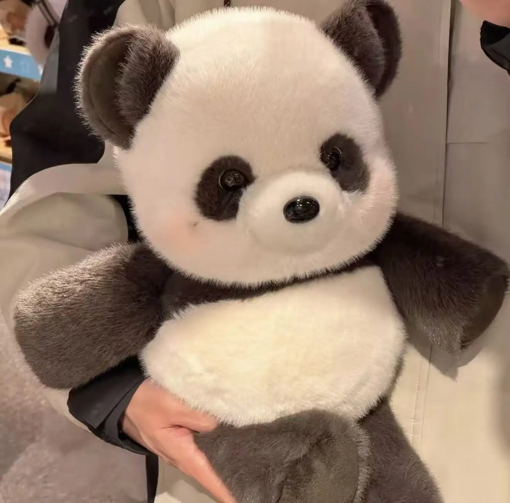 Plush panda toy held by a person with a blurred background