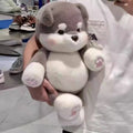 Person holding a plush toy in an indoor setting with shoes in the background